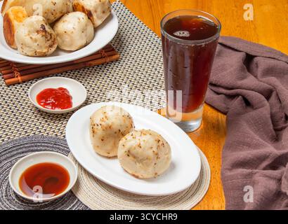 Gebratene Brötchen 2 Stück mit tauchenden Saucen und einem hohen Glas Eistee isoliert auf Serviette Seitenansicht von taiwan Dim Sum Food Stockfoto