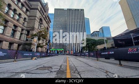 Toronto, ON, Kanada - 18. Oktober 2025: Vor einem Marathon steht eine leere Downtown Street mit Rennsperren vor einem hohen Büroturm. Stockfoto