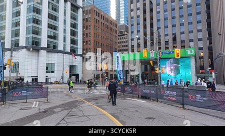Toronto, ON, Kanada - 18. Oktober 2025: Ein Polizist und sein Hund der K9-Einheit patrouillieren auf der leeren, abgesperrten Straße vor dem Start eines Maras in der Stadt Stockfoto