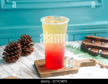 Grüner Eiskäpfel-grüner Tee mit Eiswürfel in hohem Glas, serviert auf einem Holzbrett, Seitenansicht auf taiwan kaltes Getränk Stockfoto