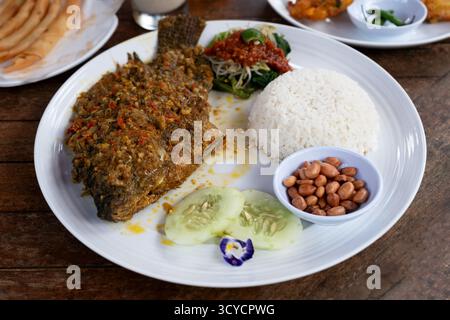 Mujair Nyat Nyat scharfe gebratene Tilapia mit Reis und Beilagen balinesische Speisen Stockfoto