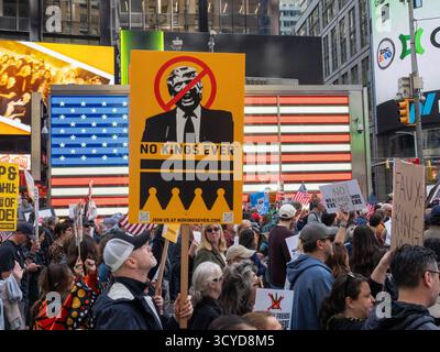 New York, New York, USA. Oktober 2025. Ein Schild mit der Aufschrift „No Kings Ever“ (keine Könige jemals) steht auf dem Times Square. Demonstranten marschieren während des No King's Day Protests am Samstag durch Midtown, prangern Monarchie und erbte Macht an und rufen zu einer globalen demokratischen Reform auf. Die Kundgebung war Teil koordinierter Aktionen in mehreren Städten weltweit. (Kreditbild: © Carlos Chiossone/ZUMA Press Wire) NUR REDAKTIONELLE VERWENDUNG! Nicht für kommerzielle ZWECKE! Stockfoto