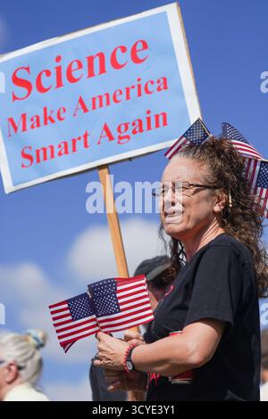 North Charleston, Vereinigte Staaten von Amerika. 18. Oktober 2025. Eine Frau, die amerikanische Flagge trägt, hält ein Protestzeichen, das US-Präsident Donald Trump während der „No Kings“-Kundgebung am 18. Oktober 2025 in North Charleston, South Carolina, anprangert. Eine geschätzte Menschenmenge von 1500 Menschen demonstriert friedlich, um ihre Opposition gegen Trumps autoritäre Politik zu zeigen. Quelle: Richard Ellis/Richard Ellis/Alamy Live News Stockfoto