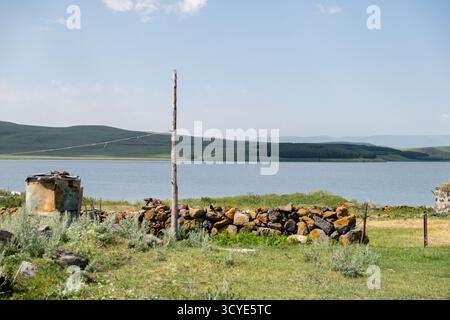 Paravani See mit einer kleinen Insel und umliegenden Wiesen auf dem Javakheti Plateau. Javakheti, Georgien. 18. Juli 2020. Stockfoto