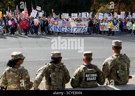 Washington DC, Washington DC, USA. Oktober 2025. Mitglieder der Nationalgarde werden beobachtet, während Demonstranten an einem Protest gegen die Regierung Donald Trump während der NO Kings-Kundgebung am 18. Oktober 2025 in Washington, DC, USA, teilnehmen. Millionen von Menschen im ganzen Land schlossen sich dem Protest "No Kings" an, um ihre Missbilligung gegenüber der aktuellen US-Regierung zu demonstrieren. Der Tag der Nichtkönige wurde organisiert, um Autoritarismus, milliardenschwere Politik und die Militarisierung der Demokratie des Landes abzulehnen, so eine Erklärung von Organisatoren. (Kreditbild: © Aa Stockfoto