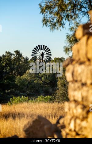 Alte Sandsteinmauer und Windmühle, Old Cork Station, Winton, Western Queensland, Australien Stockfoto