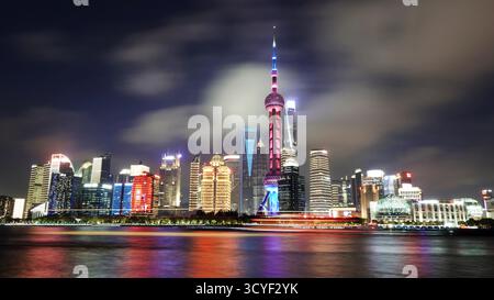 Der Bund in Shanghai erleuchtete in der Abenddämmerung mit einer langsamen Verschlusszeit und zeigte nächtliche Lichter von Booten und Schiffen auf dem Huangpu River. Blendend Stockfoto