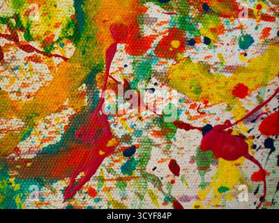 Abstrakt lebendiger Farben, die über die Leinwand gespritzt werden Stockfoto
