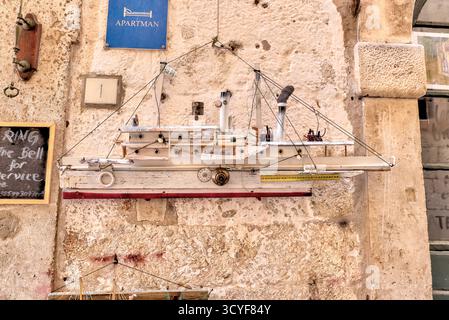 Handgefertigte Modellboote, die an den Mauern der Steingasse in der Altstadt von Dubrovnik in Kroatien ausgestellt werden, verbinden maritimen Charme mit historischer Architektur. Stockfoto