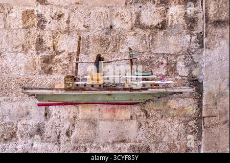 Handgefertigte Modellboote, die an den Mauern der Steingasse in der Altstadt von Dubrovnik in Kroatien ausgestellt werden, verbinden maritimen Charme mit historischer Architektur. Stockfoto