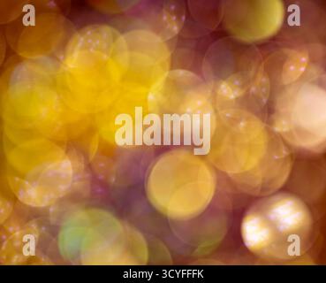 Hellgelbes Bokeh auf dunklem Hintergrund – festliche Glitzerlichter und verschwommener Silvester-Hintergrund Stockfoto