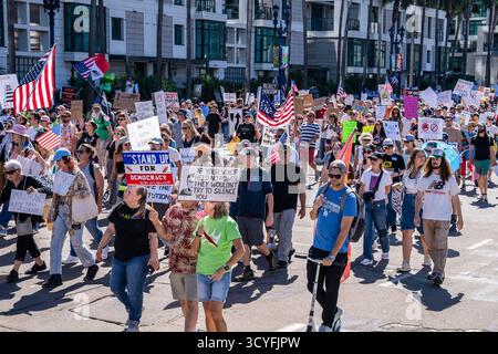 Demonstranten marschieren mit amerikanischen und mexikanischen Flaggen durch die Innenstadt und halten Plakate zur Verteidigung der Demokratie und der Rechte von Einwanderern während der Demonstration. Demonstranten versammelten sich in der Innenstadt von San Diego, Kalifornien, um an den landesweiten „No Kings“-Demonstrationen teilzunehmen. Auf dem Marsch vom Civic Center Plaza zum Waterfront Park äußerten sich die Teilnehmer gegen den Autoritarismus der Regierung und die jüngste Bundespolitik unter Präsident Donald Trump. Der Protest, einer von Hunderten in den Vereinigten Staaten, enthielt Banner, Gesänge und Aufführungen, die Demokratie, Gleichheit und Freiheit des Ausdrucks forderten Stockfoto