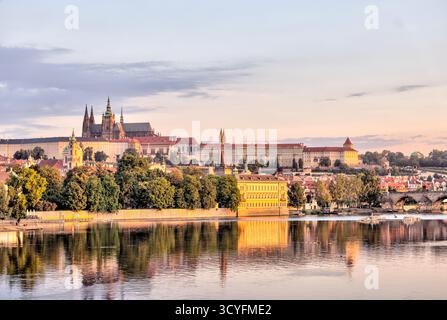 Vormittagsblick über die Moldau in Richtung historischer Türme und Gebäude der Prager Altstadt, Tschechien, mit Reflexionen im ruhigen Wasser. Stockfoto