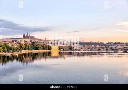 Vormittagsblick über die Moldau in Richtung historischer Türme und Gebäude der Prager Altstadt, Tschechien, mit Reflexionen im ruhigen Wasser. Stockfoto
