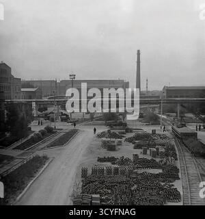 Dieses Archivfoto aus den 1970er Jahren bietet einen Panoramablick auf die Slawjansk Armature-Isolator Plant (AIZ) in Sloviansk, UdSSR. Die Aufnahme fängt die riesige Industrielandschaft ein und zeigt verschiedene Werkstätten, interne Straßen, erhöhte Pipelines und einen hohen Schornstein. Das Gebiet umfasst Freiluftlager mit fertigen Isolatoren, Gleisanschlüsse und Verwaltungsgebäude. Arbeiter sind auf dem Gelände sichtbar. Im Hintergrund erstreckt sich der Fabrikkomplex zu einem Fluss, der am Horizont sichtbar ist Stockfoto