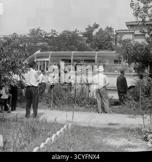 Dieses Archivfoto aus den 1970er Jahren zeigt eine Sommerszene in Sloviansk, UdSSR. Eine Gruppe von Menschen, Männer und Frauen in leichter Kleidung, versammelt sich an einem Straßenrand. Sie warten darauf, an Bord eines alten sowjetischen Intercity-Busses zu gehen, wahrscheinlich ein LAZ-697-Modell für einen kollektiven Ausflug. Dieses Bild zeigt einen typischen Aspekt des gesellschaftlichen Lebens in der Sowjetzeit, wie etwa eine werkseitig organisierte Freizeitreise für Arbeiter Stockfoto