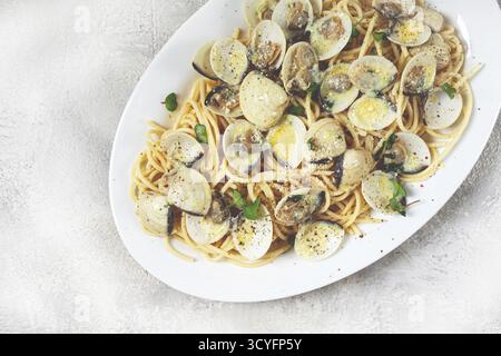 Spaghetti mit Vongole Venusmuscheln, in Sahnesauce, Carbonara, auf einem weißen Teller, hausgemacht, Blick von oben, keine Leute Stockfoto