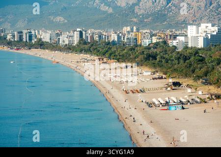 Blick aus der Vogelperspektive auf den Strand von Konyaalti und die mit Kiefern bedeckte Küste bei Sonnenaufgang in Antalya Stockfoto