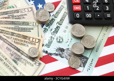 US-Dollar-Geldscheine und Taschenrechner auf amerikanischer Flagge Nahaufnahme. Geldinvestitionskonzept und Steuerzahlung Stockfoto
