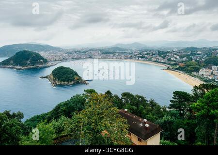 Panoramablick auf die Bucht von La Concha und die Insel Santa Clara, Stadt San Sebastian (Donostia), die sich entlang der Küste erstreckt, vom Berg Igeldo aus gesehen Stockfoto
