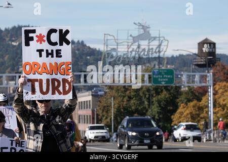 Portland, USA. Oktober 2025. Während des landesweiten „No Kings“-Protestes gegen die autoritäre Politik von Präsident Trump am 18. Oktober 2025 in Portland, Ore., geht ein Demonstrant über die Burnside Bridge. (Foto: Alex Milan Tracy/SIPA USA) Credit: SIPA USA/Alamy Live News Stockfoto