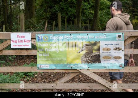 Schilder an einem großen Tor zum Waldweg am St Ives Estate Bingley, in dem man darauf hinweist, die Enten nicht zu füttern und das Tor für den Zugang freizuhalten Stockfoto