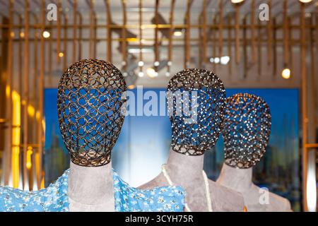 Futuristische Schaufensterpuppen mit Metallköpfen in einem beleuchteten Raum Stockfoto