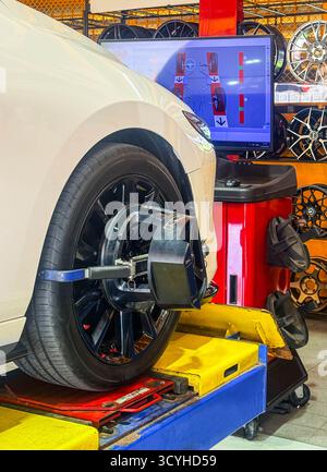 Radausrichtung am Ständer mit Sensoren in der Servicestation prüfen. Fahrzeug in der Werkstatt für automatische Sturzbefestigungen, Fahrzeug in der Garage Stockfoto