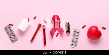 Rotes Band mit Pillen, Reagenzgläsern und Herz auf rosa Hintergrund. Blutkrebs-Sensibilisierungsmonat Stockfoto