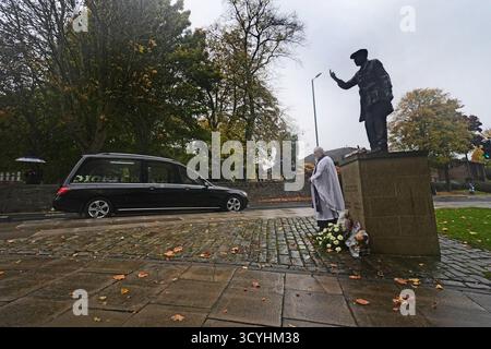 Das Trauerkortege des ehemaligen Testumpire Harold „Dickie“ Bird, der im September im Alter von 92 Jahren starb, geht an seiner lebensgroßen Bronzestatue vorbei, die zu seinem Trauergottesdienst in der nahe gelegenen St. Mary's Church in Barnsley führt. Bilddatum: Sonntag, 19. Oktober 2025. Stockfoto