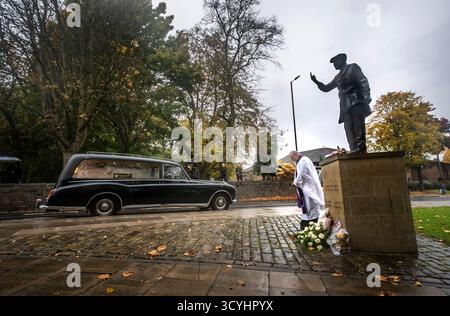 Der Trauerzug für Dickie Bird führt an der lebensgroßen Bronzestatue von Dickie Bird in der Nähe der St. Mary’s Church in Barnsley vorbei. Bilddatum: Sonntag, 19. Oktober 2025. Harold „Dickie“ Bird starb im September im Alter von 92 Jahren. Stockfoto