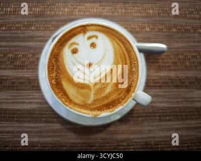 Nahaufnahme einer Tasse Cappuccino mit einem Lächeln Stockfoto
