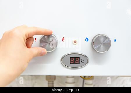 Drehknopf am modernen Gas-Warmwasserbereiter mit Digitalanzeige zur Regelung von Wassertemperatur und Wassermenge, Heizelement und Energieregelung Stockfoto