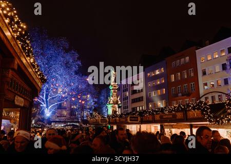 Köln, Deutschland - 11. Dezember 2022: Besucher genießen den Weihnachtsmarkt unter leuchtend blauen Bäumen und hellen Ständen im Herzen von Köln, Christma Stockfoto