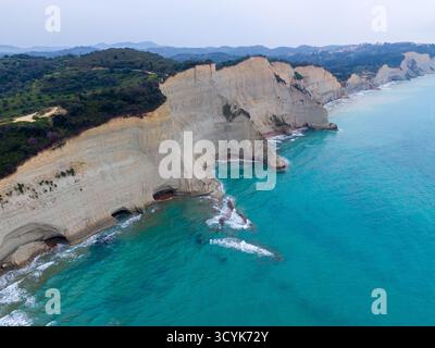 Dramatischer Blick aus der Luft auf Kap Drastis, Korfu, Griechenland, mit markanten weißen Klippen, einzigartigen erodierten Formationen und lebendigem türkisfarbenem Ionischen Meer. Stockfoto