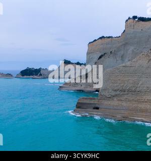 Dramatische, abgelegene und atemberaubende Aussicht auf Kap Drastis in Korfu, Griechenland, mit einzigartigen erodierten Kalksteinklippen und türkisfarbenem Ionischen Meer in der Abenddämmerung. Stockfoto