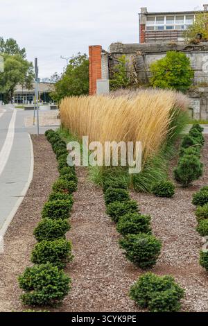 Ein flacher Schuss, der von der massiven gelben Metallstruktur eines Frachtkrans dominiert wird, der über einem Stapel hellblauer Kunststoffbehälter in einem indus thront Stockfoto