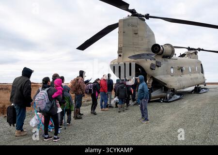 Kwigillingok, Vereinigte Staaten von Amerika. Oktober 2025. Die Bewohner stellen sich an Bord eines Hubschraubers der Alaska Army National Guard CH-47 Chinook während der Evakuierung nach extremen Wetterbedingungen, die durch die Überreste des Taifuns Halong am 16. Oktober 2025 in Kwigillingok, Alaska verursacht wurden. Der Sturm verdrängte mindestens 1500 Ureinwohner und ließ Dörfer in Trümmern zurück. Gutschrift: SSgt. Joseph Moon/Alaska National Guard Photo/Alamy Live News Stockfoto