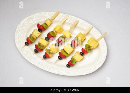 Bunte Käse- und Veggie-Spieße, verschiedene Spieße mit Käse und Gemüse auf elegantem Teller Stockfoto