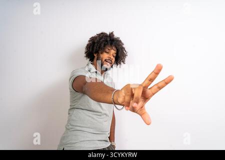 Junger Mann posiert selbstbewusst und zeigt eine ungezwungene Handgeste Stockfoto