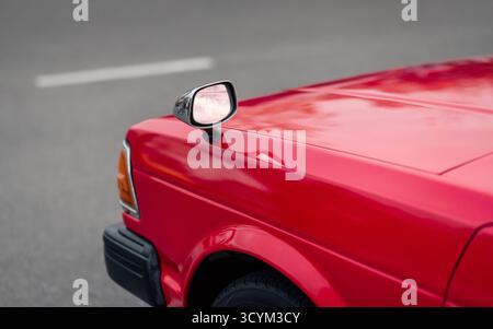 Red japanese 1980s car with fender mirrors. Side front part of old JDM car - view from the back. Stockfoto