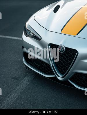 Vorderer Teil aus silbernem Alfa Romeo Giulia QV mit gelbem Streifen auf der Kapuze. Nahaufnahme einer modernen italienischen Sportlimousine. Stockfoto