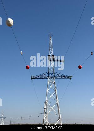 Farbige Plastikkugeln, die an den Stromleitungen hängen, werden als Luftmarkierungskugeln bezeichnet, viisual warnen also tief fliegende Flugzeuge Stockfoto