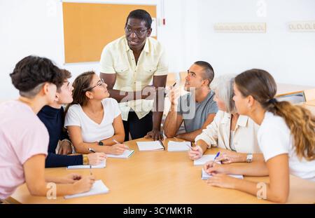 Multirassische gemischte Altersgruppe, die an der Erwachsenenbildungsklasse mit afroamerikanischem Tutor teilnimmt Stockfoto