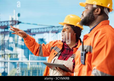 Offshore-Plattform-Engineering-Team verwendet Überwachungsprogramm auf Tablet, um Emissionen zu verfolgen und die Umwelt zu schützen. Teamkollegen führen Umweltverträglichkeitsprüfungen für Bohrfahrzeuge durch Stockfoto