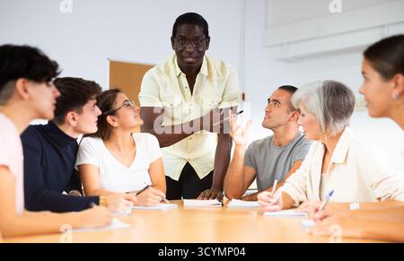 Multirassische gemischte Altersgruppe, die an der Erwachsenenbildungsklasse mit afroamerikanischem Tutor teilnimmt Stockfoto