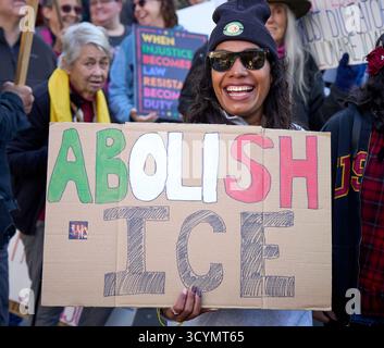 Eine Frau hält ein Schild, während sie am 18. Oktober 2025 in Eugene, Oregon, bei einer No Kings Demonstration marschiert. Stockfoto