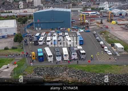 GREENOCK, SCHOTTLAND - 19. August 2024: Dutzende Reisebusse stehen am Kreuzfahrthafen Greenock an, während Passagiere für Ausflüge nach Glasgow an an Bord gehen Stockfoto