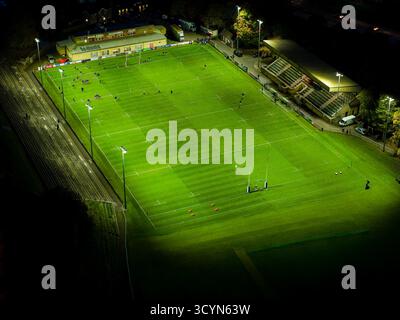 Hochwinkelansicht eines üppig grünen Rugbyfeldes, beleuchtet durch helle Flutlichter Stockfoto