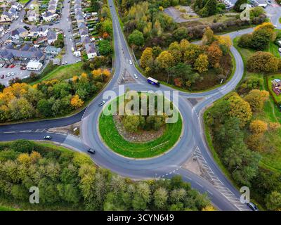 Drohnenansicht eines Kreisverkehrs und einer Stadt, umgeben von bunten Herbstbäumen in Wales Stockfoto